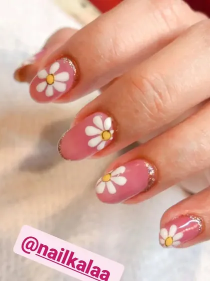 A sweet and simple design featuring a pink base with hand-painted white daisies. A touch of glitter around the cuticles adds a little sparkle.