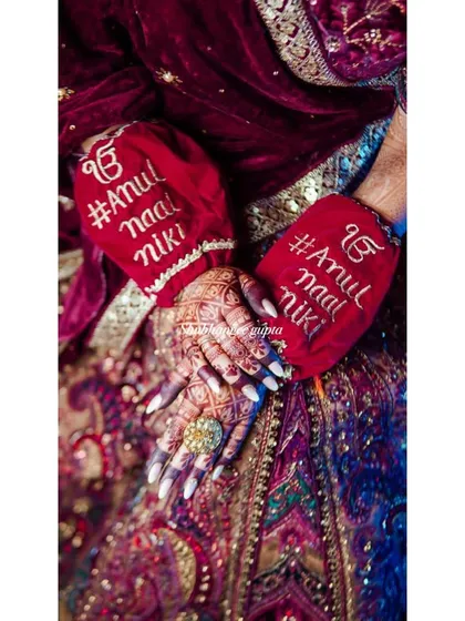 A beautiful detail shot from a wedding, showing the bride's henna and her custom hand-warmers with the wedding hashtag. It's all about those personal touches.
