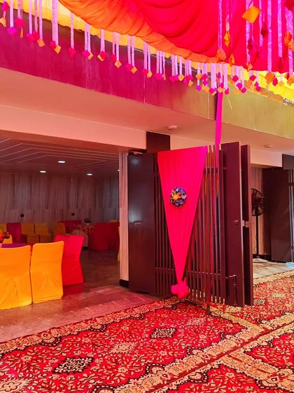 The entrance to a housewarming party, showing the decorated gate and the transition into the main event area.