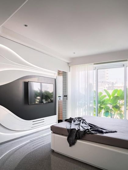 Reflecting an edgy, modern personality, this son's bedroom in Apartment 56 features a fluid, black-and-white wall system with integrated lighting. The custom unit combines the bed, storage, and media center into a single sculptural element.