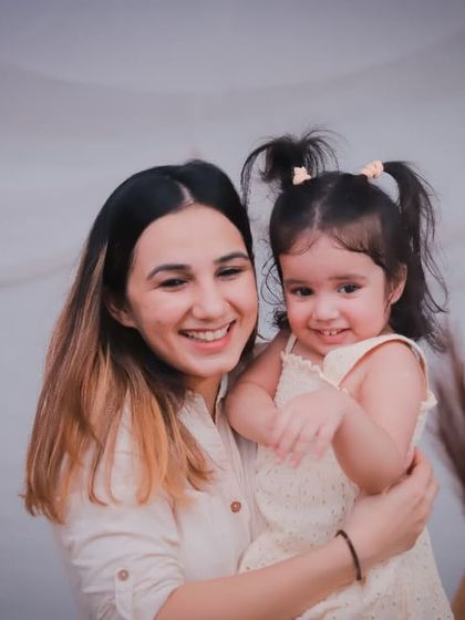 A joyful, candid moment between a mother and her daughter. Her little girl's smile is absolutely infectious!