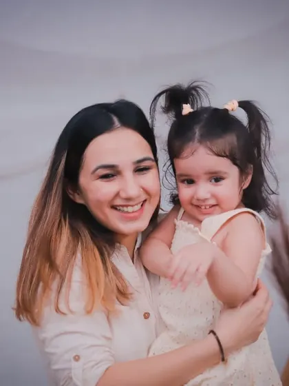 A joyful, candid moment between a mother and her daughter. Her little girl's smile is absolutely infectious!