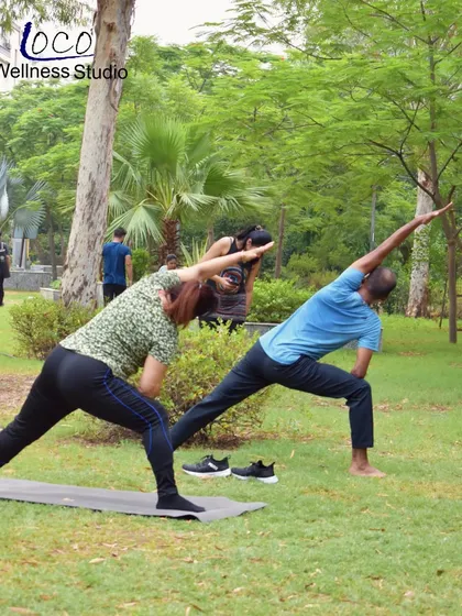 The extended side angle pose, demonstrated here by two clients in our park yoga session, is fantastic for stretching the entire side of the body and building strength in the legs.