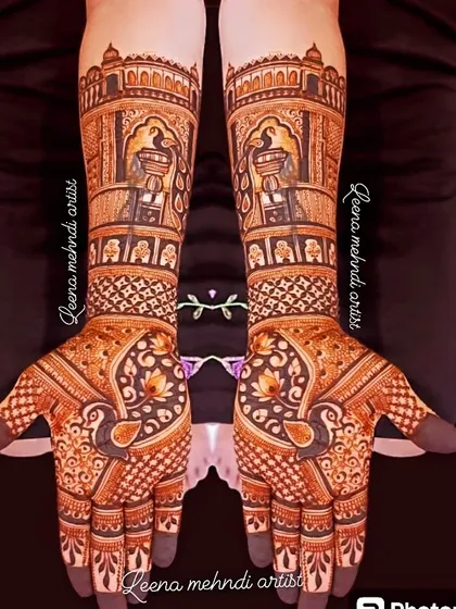 Architectural elements are a popular choice for bridal mehndi. This design features palace-like structures and jharokhas, with peacocks and lotuses adding a touch of traditional elegance.
