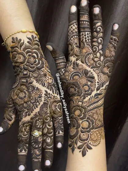 A close-up of the dense floral and paisley work in this full-hand mehendi design.