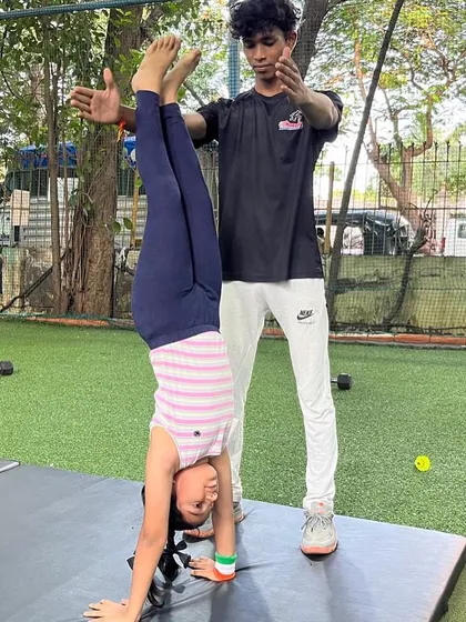Safety and proper technique are at the heart of our gymnastics coaching. A coach carefully spots a young athlete as she perfects her handstand, building balance, strength, and body awareness step by step.