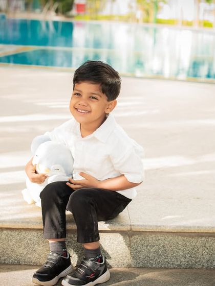 A happy boy enjoying the outdoors, sitting by a poolside. These relaxed, candid shots are perfect for capturing a child's natural happiness.