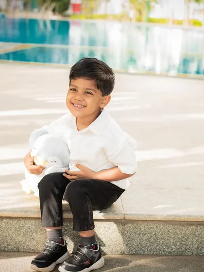 A happy moment by the pool. Outdoor locations provide beautiful backdrops for kids' and family portraits.