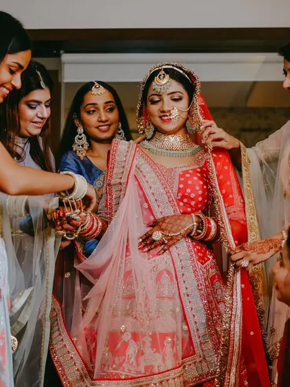 The bridesmaids help adjust the bride's veil, a classic wedding day shot.