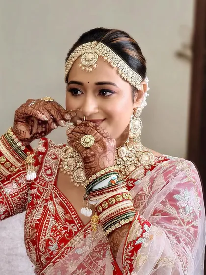 A candid moment of the bride adjusting her nose ring. Her soft smile and glowing makeup reflect the happiness of her special day.