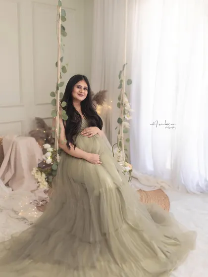 A full-length view of the olive gown on the swing set. This shot showcases the entire dreamy, bohemian-inspired studio setup, which is one of my most requested styles.