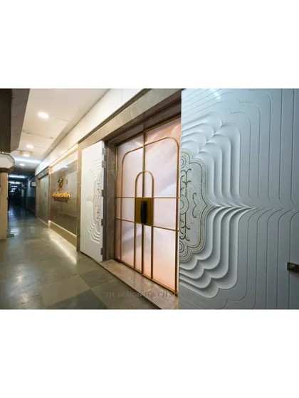 A full view of the CNC-cut Corian door alongside a frosted glass door with golden frames. This juxtaposition highlights our versatility in designing entrances that range from artistic and bold to elegantly simple.