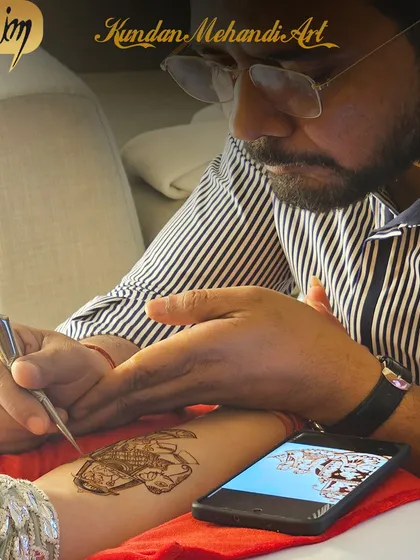 Using a reference photo on a phone to ensure the custom design is exactly what the client wants. Precision is key.