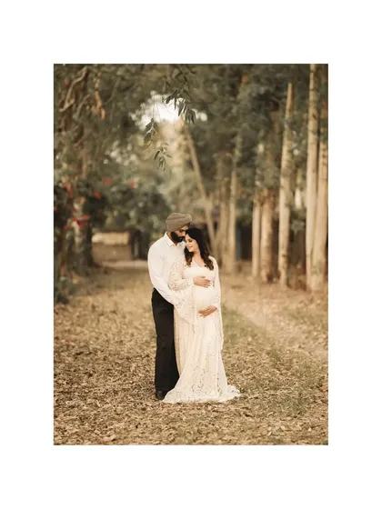 A timeless portrait of the couple in a forest of tall, slender trees. The composition and earthy tones create a sense of peace and enduring love.