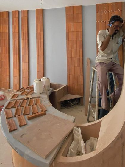 A construction site photo showing the framework for a curved reception desk and the start of brick cladding on the wall. This is where ideas start to take physical form.