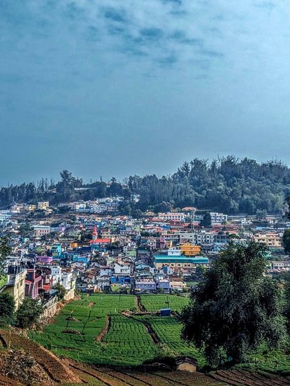 A panoramic view of Coonoor, near Ooty, with its colorful houses nestled among the tea estates. The toy train ride offers many such picturesque sights.