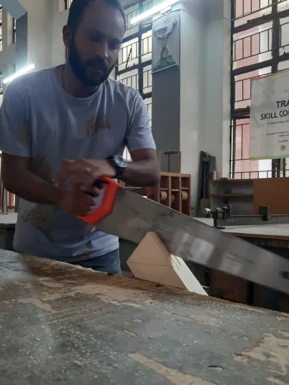 A student practices making a straight cut with a handsaw. Mastering this basic skill is a cornerstone of woodworking and is emphasized in our conventional woodworking course.