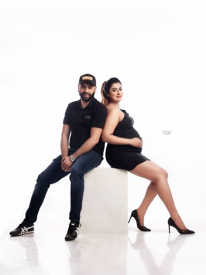 A cool and casual couple portrait. The back-to-back pose and their relaxed outfits give this maternity shoot a modern, edgy, and confident vibe.