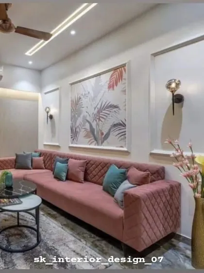 A plush, quilted sectional sofa in dusty rose provides ample seating in this living room. The large piece of abstract art and wall sconces add character and warmth.