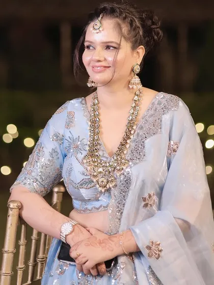 An elegant party look in a powder blue lehenga. The makeup is soft and radiant, paired with a statement necklace.