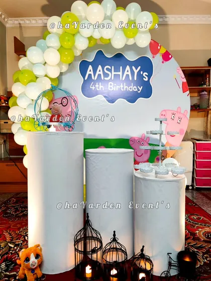 A Peppa Pig themed setup with a character backdrop and simple balloon garland.