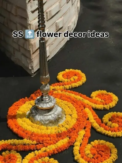 A creative rangoli design around a traditional lamp stand (samai). I used orange and yellow marigold petals to create a swirling pattern on the floor.