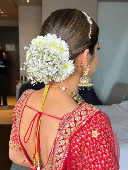 A beautiful, full bridal bun covered in a mix of white baby's breath and daisies. This is a fresh and lovely take on the traditional floral bun.