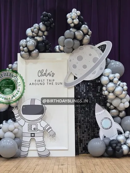 A sleek, monochromatic space theme for a "First Trip Around the Sun". The black, silver, and grey balloons against a dark curtain create a dramatic and stylish deep-space effect.