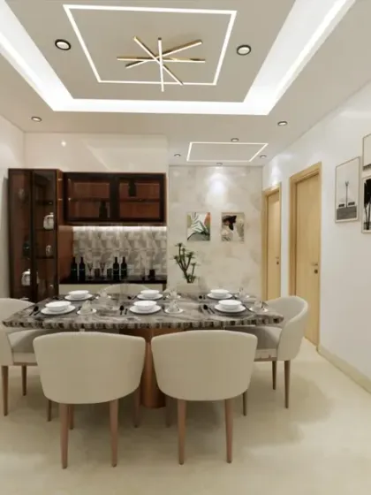 A bright and airy dining space featuring a marble-top table, comfortable upholstered chairs, and a dark wood crockery unit. The modern ceiling design and gallery wall add a touch of contemporary style.