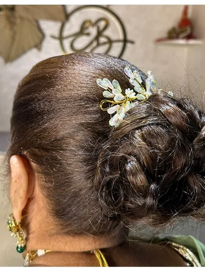 A neat and intricate braided bun, finished with a delicate crystal hair accessory. This style is perfect for keeping hair off the face while still looking elegant.