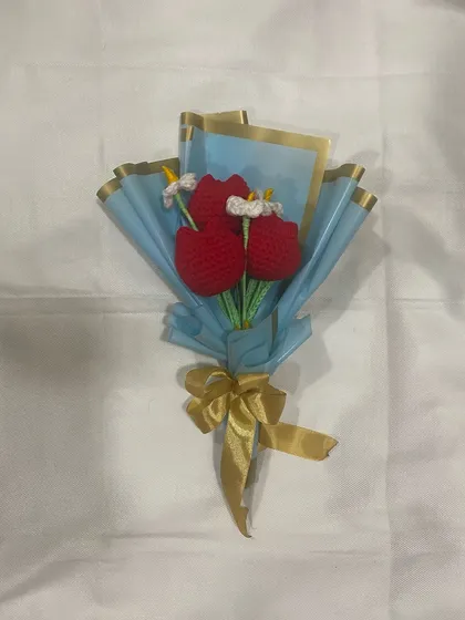 A flat lay of the red tulip and daisy bouquet, showcasing its simple beauty and clean design.