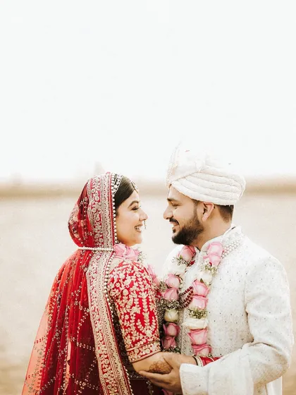 A sweet, smiling moment between the couple. The bride's makeup is soft and natural, perfect for capturing these candid, love-filled memories.