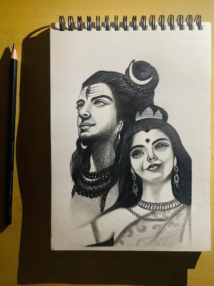A different angle of the finished Shiv Parvati sketch, with a pencil for scale. It shows the fine detail work on their ornaments and expressions.