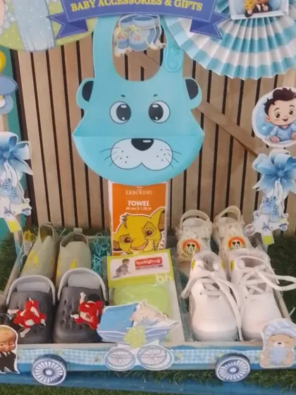 The baby accessories cart from the 'Nanihal Express', featuring baby shoes, bibs, and towels.