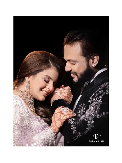 A tender moment between the couple, showcasing the intricate henna design on the bride's hand. We capture both the grand moments and the beautiful, small details.