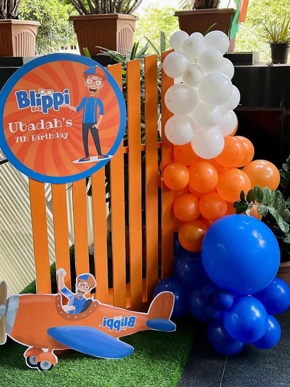 A welcome sign and entrance decor for the Blippi-themed birthday party. We used the signature orange and blue colors and a fun airplane prop to greet the guests.