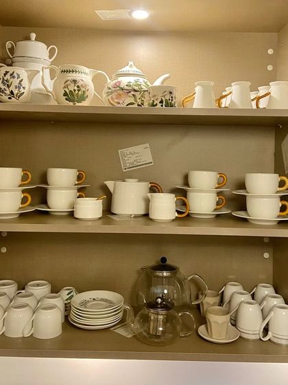 A stunning display of teapots and cup sets. We treat organizing beautiful collections like this as a styling exercise, ensuring the result is as lovely as it is practical.
