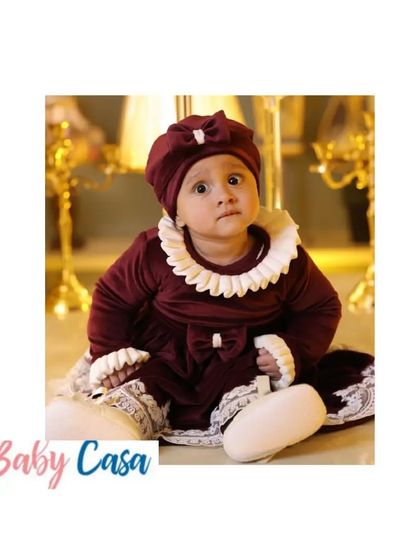 A beautiful baby girl embracing the winter season in our cozy and stylish maroon velvet dress with a vintage lace collar.