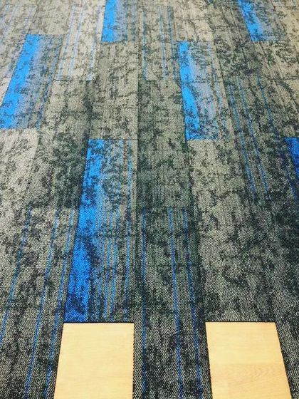 This shows carpet tile installation in progress for a commercial office space. These tiles are durable, easy to replace, and great for creating custom patterns in high traffic areas.
