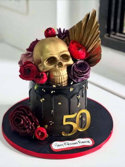 Turning 50 never looked this bold. This custom black and gold skull cake was crafted for a celebration with personality and a touch of drama, featuring a metallic skull and deep red florals.