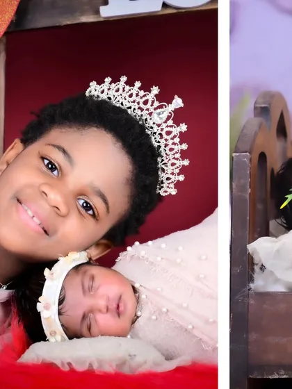 A portrait of an older sister proudly posing with her sleeping newborn sibling.
