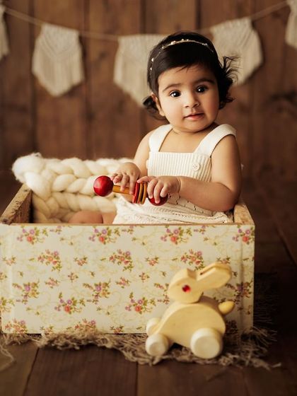 Playing with a wooden rabbit toy, a perfect candid moment.