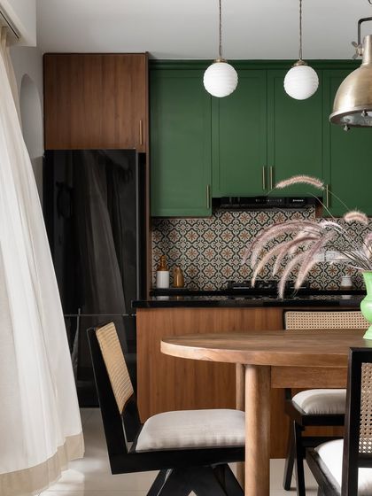 This shot shows the connection between the dining area and the kitchen, with the green of the kitchen cabinets echoing in the decor of the dining space.