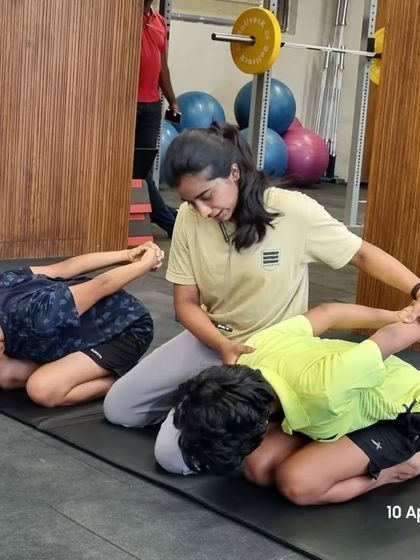 Hands-on guidance during stretching is important for young athletes to ensure correct form and prevent injury. Here, I'm assisting with a child's pose stretch to release tension in the back.