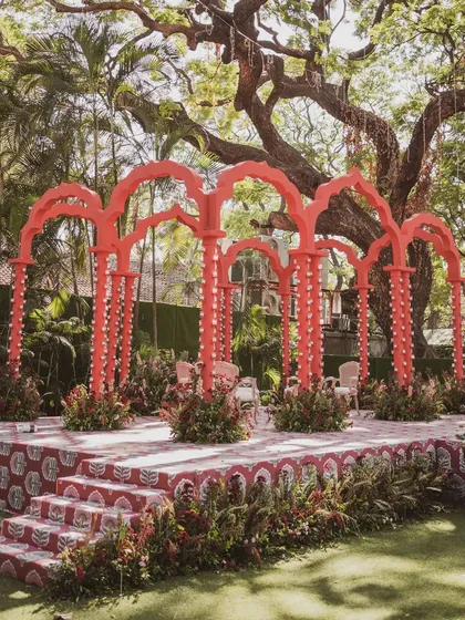 A striking 'Gulal Bagh' wedding mandap in a bold, monochromatic red. Inspired by the architecture of old Jaipuri havelis, this design uses custom Ajrak patterns and dramatic arches to create a contemporary yet traditional statement.
