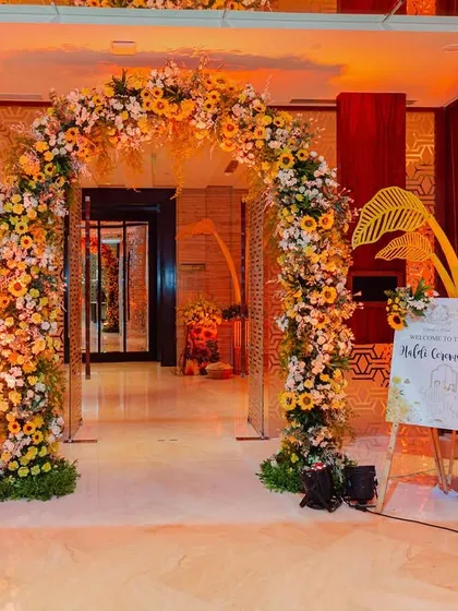 The grand entrance to the sunflower-themed Haldi, featuring a beautiful floral arch and themed decor elements that set a warm and welcoming tone.