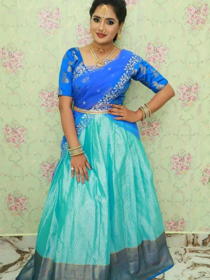 This vibrant Langa Voni combines a royal blue top with a sea green brocade skirt. It's a complete traditional outfit available for rent, perfect for wedding guests who want a classic look.