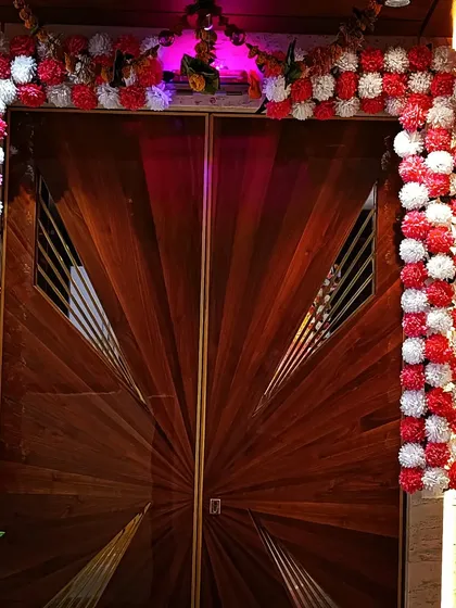 The festive decor extends to the front door. A beautiful arch of red and white marigold flowers welcomes guests and sets a divine tone for the Ganpati festival.