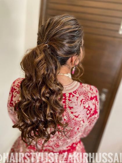 A textured, messy ponytail with a lot of volume at the crown. This is a chic and modern style, perfect for a cocktail party or an evening reception.