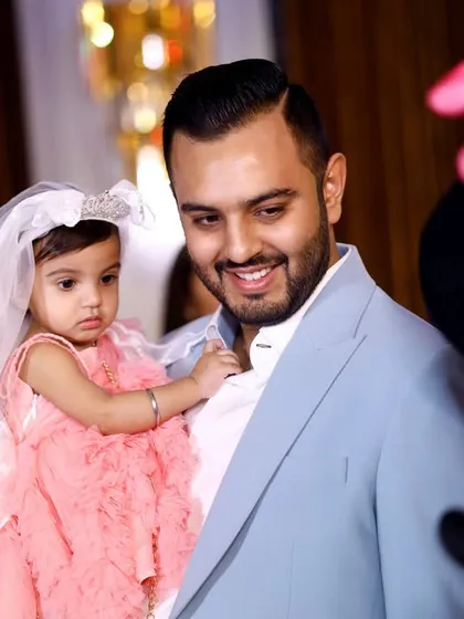 A father's proud smile as he holds his daughter, with a Minnie Mouse mascot looking on. Capturing interactions with themed elements is part of the fun.